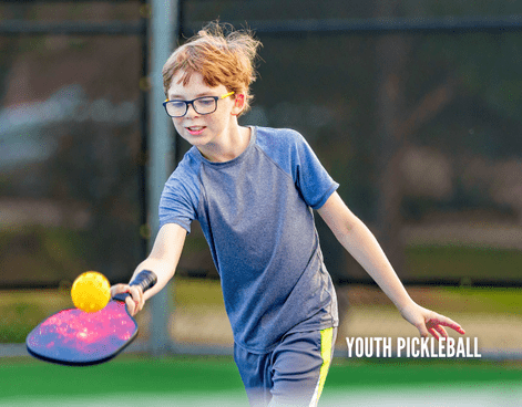 Youth pickleball player hitting a ball on an outdoor court during a youth pickleball program through Lifetime Activities.